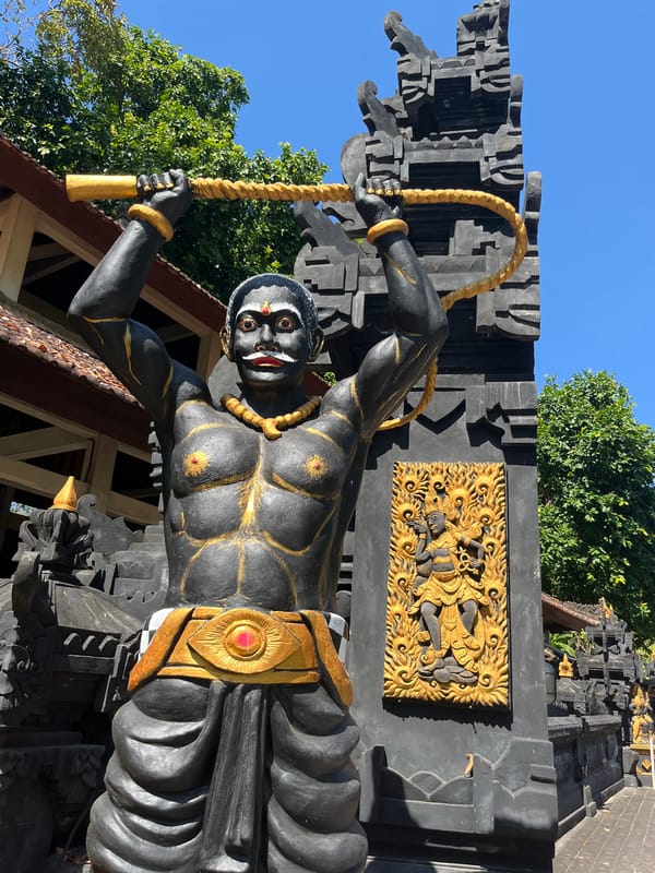 Ornate statues and dragon sculptures at a Balinese temple entrance