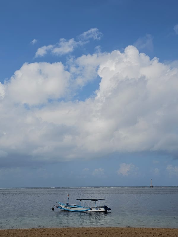 Traditional outrigger boats on a calm Sanur beach, Bali
