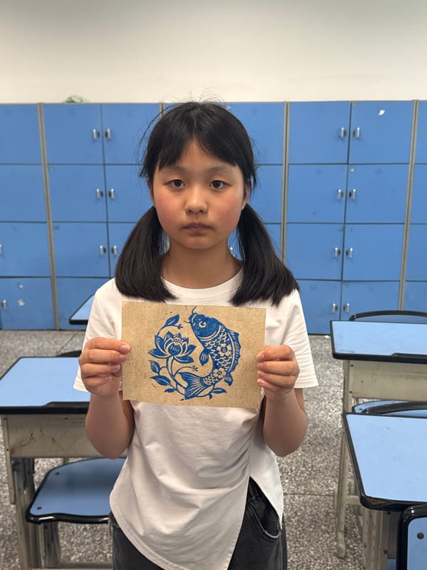 Students create blue fish art prints in Longta classroom