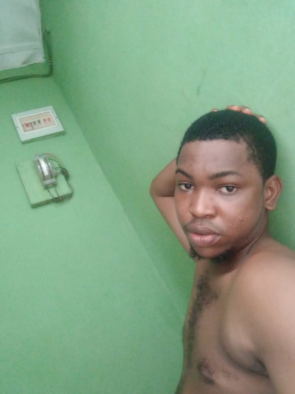 Man photographed against green wall in Ughelli, Nigeria