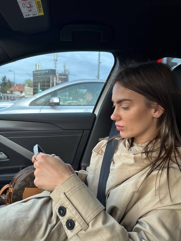 Woman in trench coat observed in car passenger seat, Warsaw