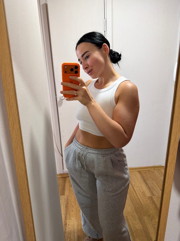 Woman takes mirror selfies with orange phone indoors