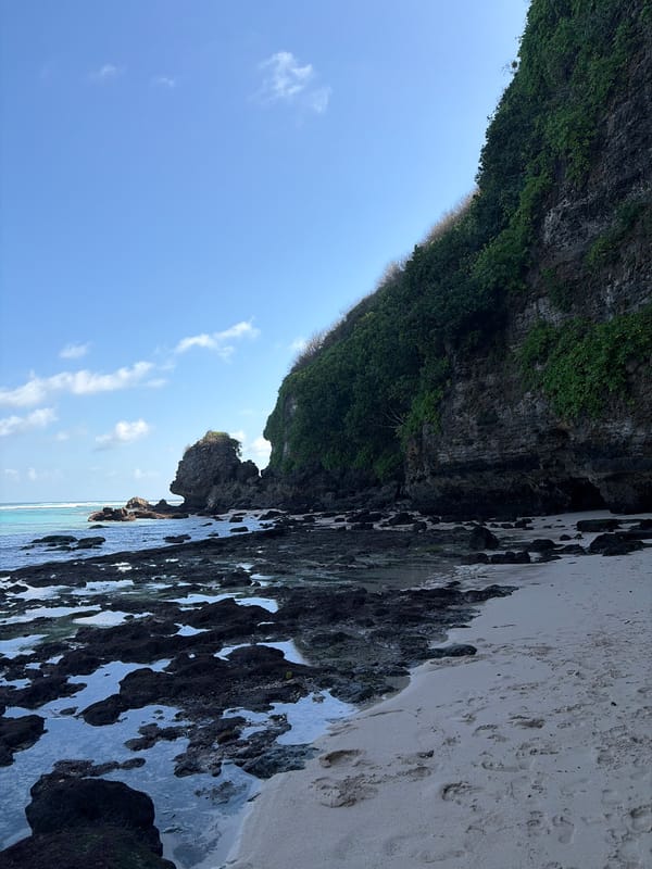Morning beach scene at a Kuta Selatan cliff-backed shore