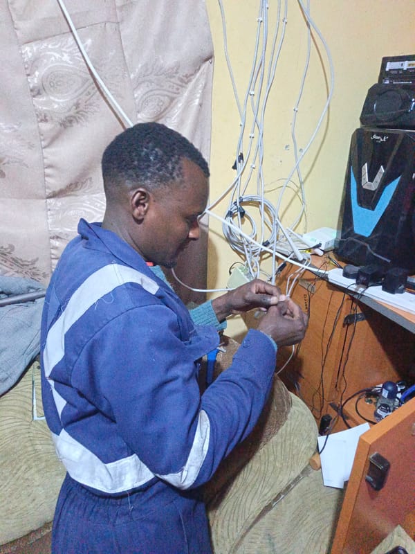 Technician performs electrical work on computer equipment in Nairobi