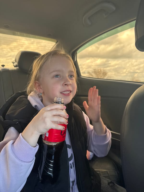 Child drinks Coca-Cola in car backseat in Kurganinsk