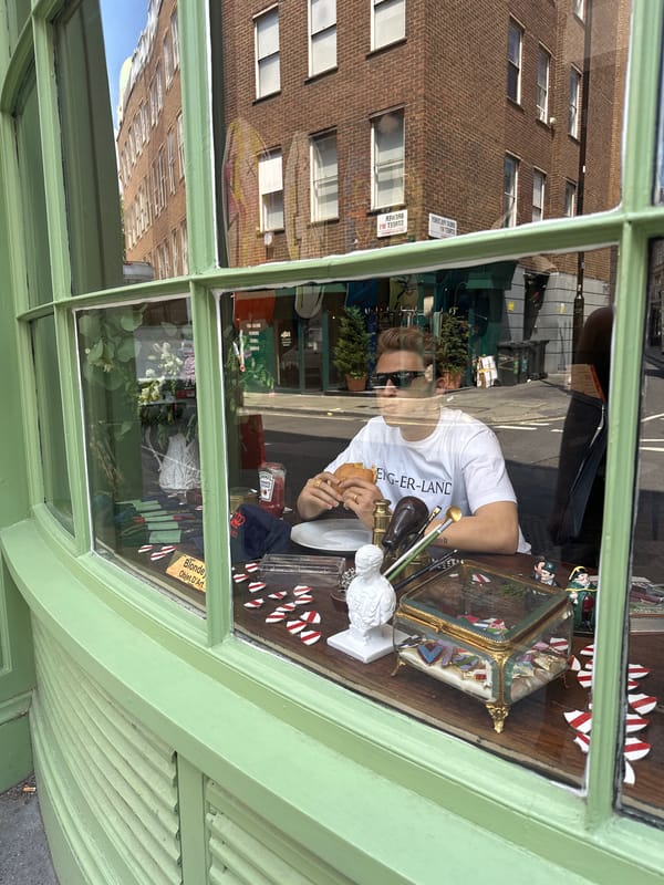 Hamburger in hand at a London shop counter