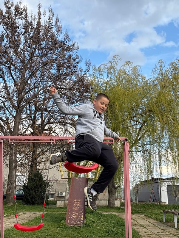Young person rests on swing set in park area