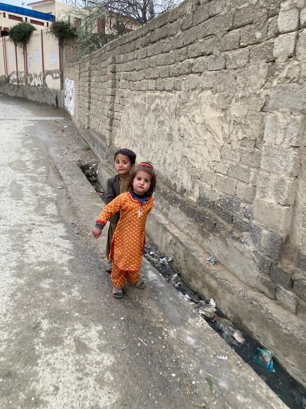 Two children pose for camera on Quetta street