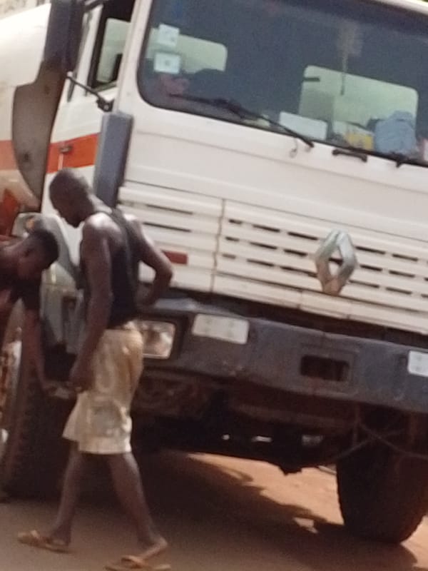Two men inspect Renault truck tire in Tamale