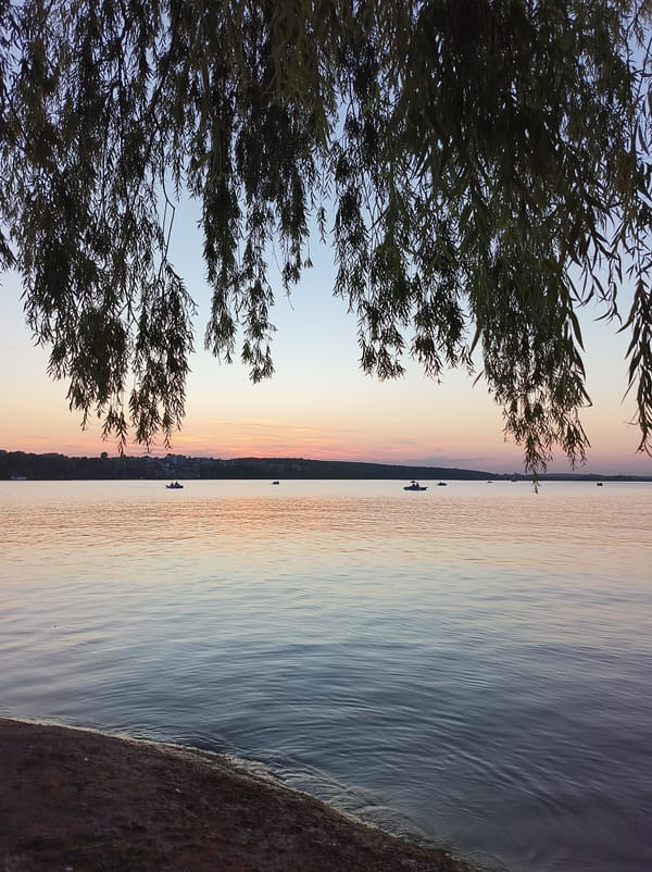 Summer sunset over Ternopil Lake, pedal boats on the water
