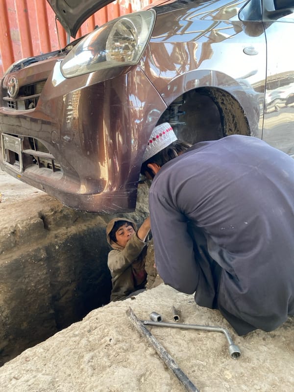 Auto repair yard activity documented in Kandahar morning hours