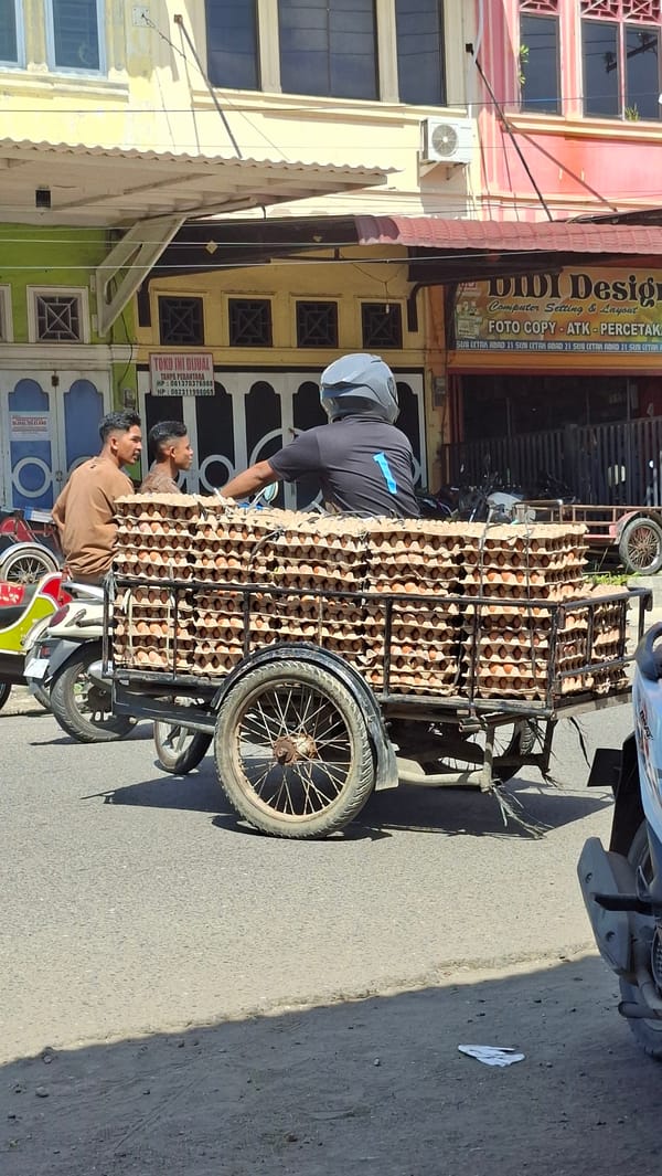 Morning street life and commerce moving through Lhokseumawe