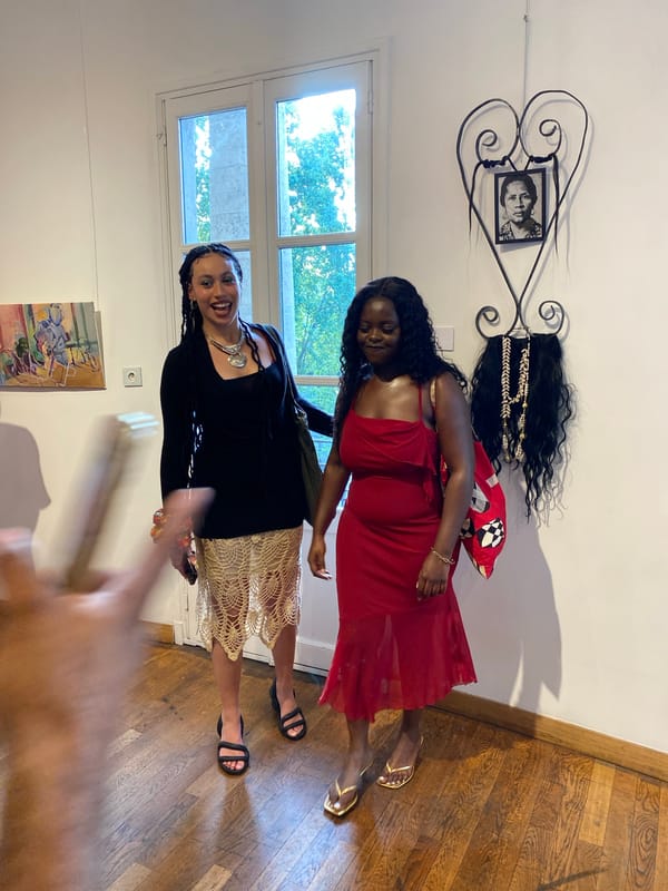 Women pose for photos at Paris art gallery