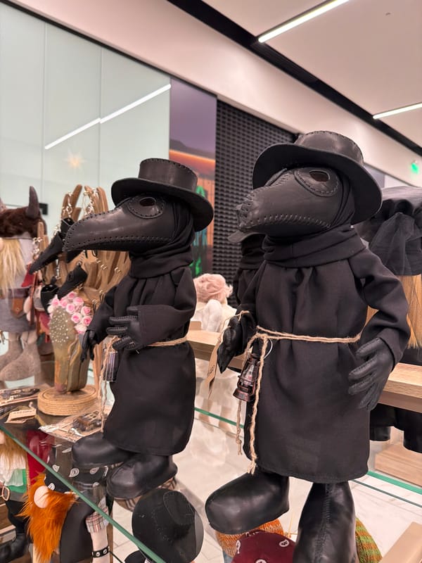 Plague doctor dolls displayed in glass case in Murino