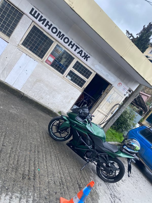 Motorcycle parked outside tire service shop in Sochi