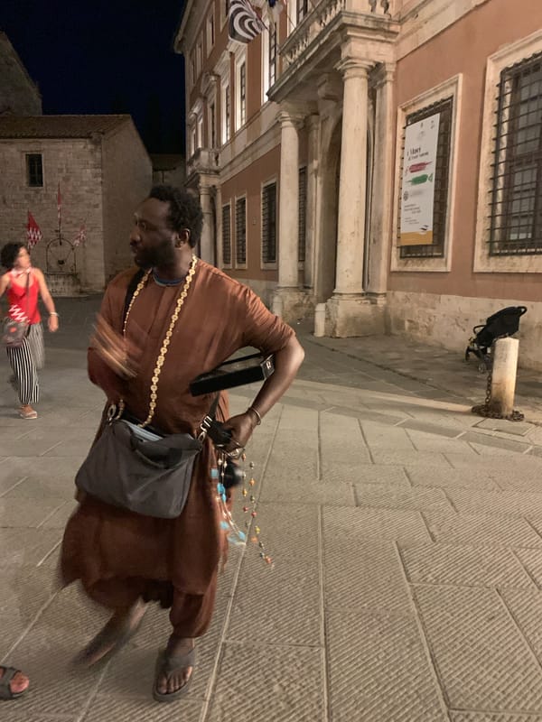 Red-and-white crowd fills San Quirico d'Orcia streets at night