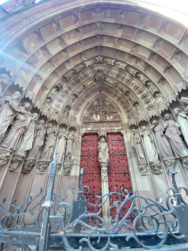 Visitor documents ornate cathedral architecture in Strasbourg