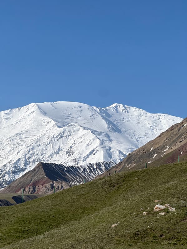 Snow-capped peaks and striated rock formations in Kyrgyzstan mountains