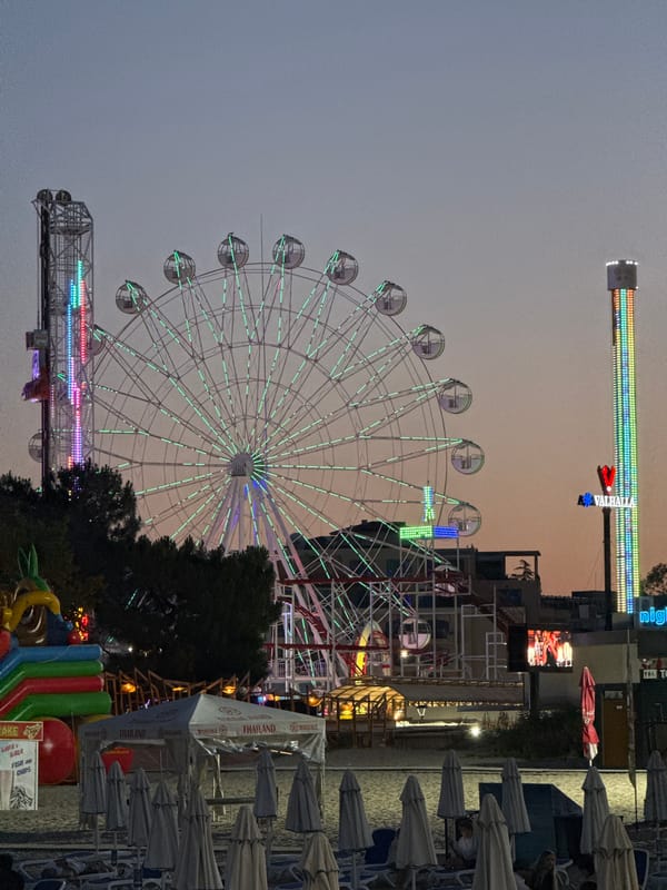 Evening at a beachside fairground with rides and arcade games