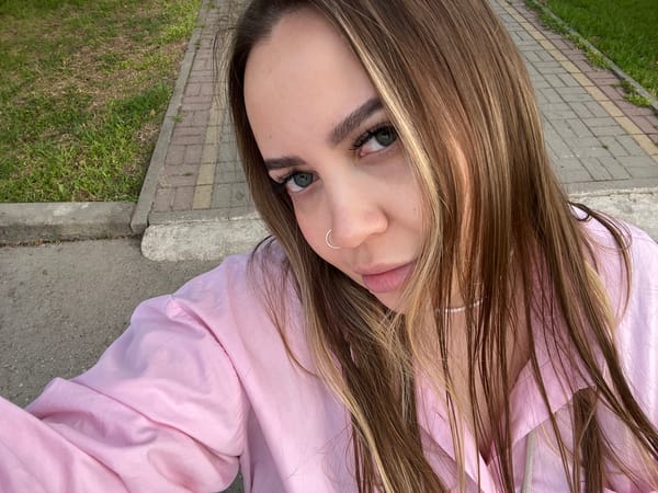 Woman rests on pavement amid spring blooms in Russian town