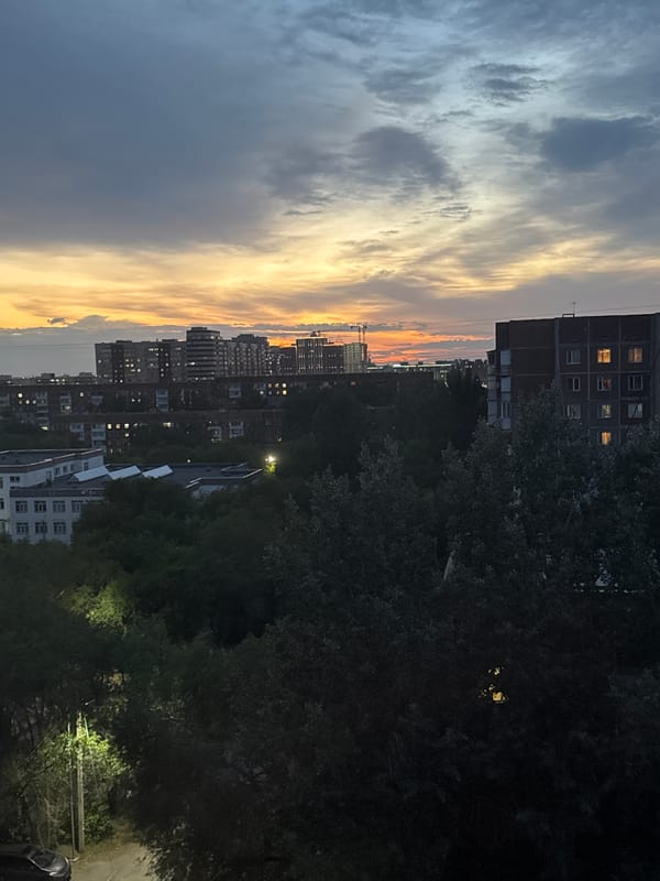City skyline glows under a dramatic dusk sky