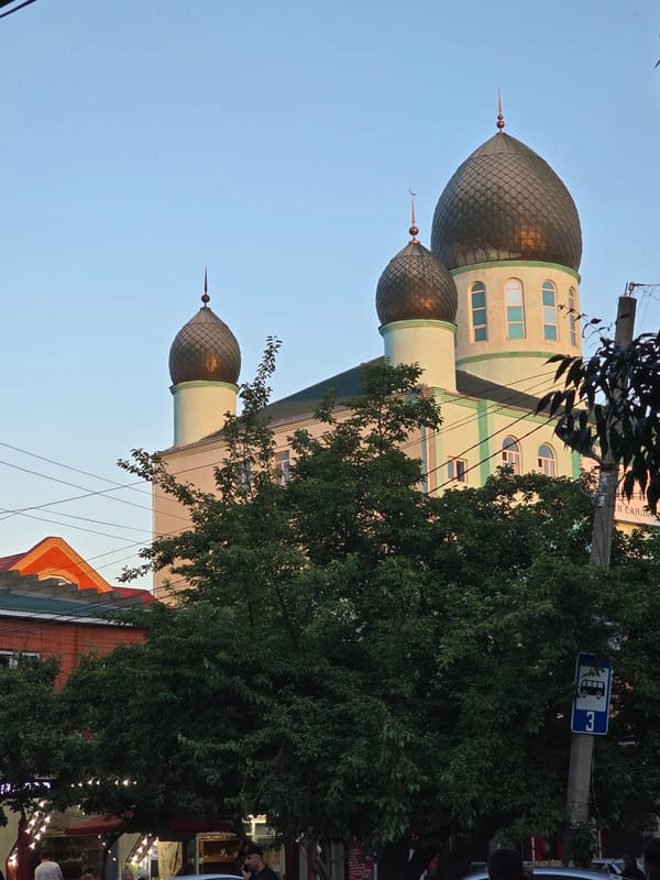 Mosque exterior and small objects on a dark speckled surface