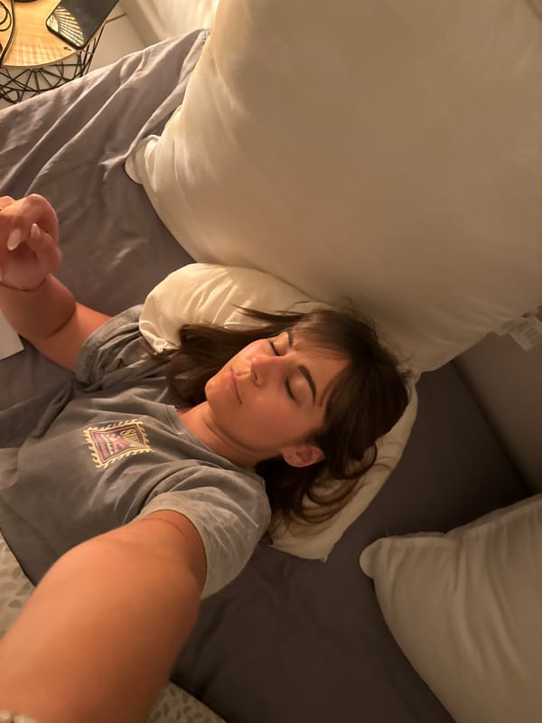 Woman rests in bed wearing Surf Bali shirt in Cannes