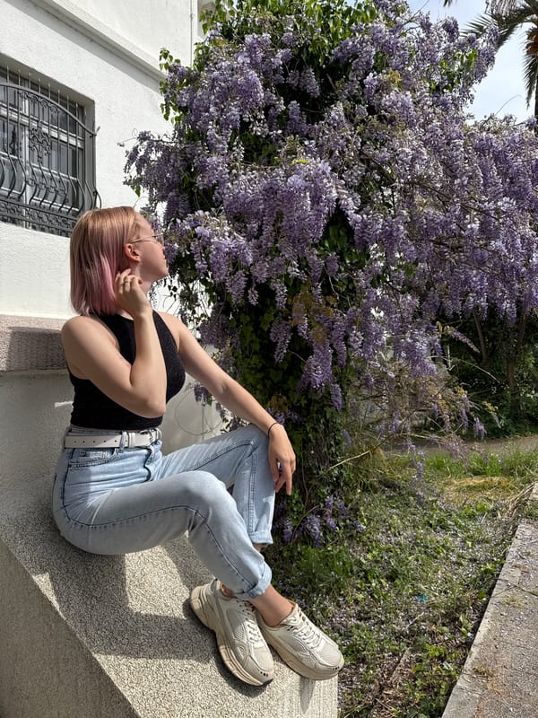Woman poses with wisteria blossoms in Bar, Montenegro