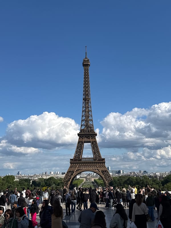 Crowds gather at Eiffel Tower on clear spring afternoon