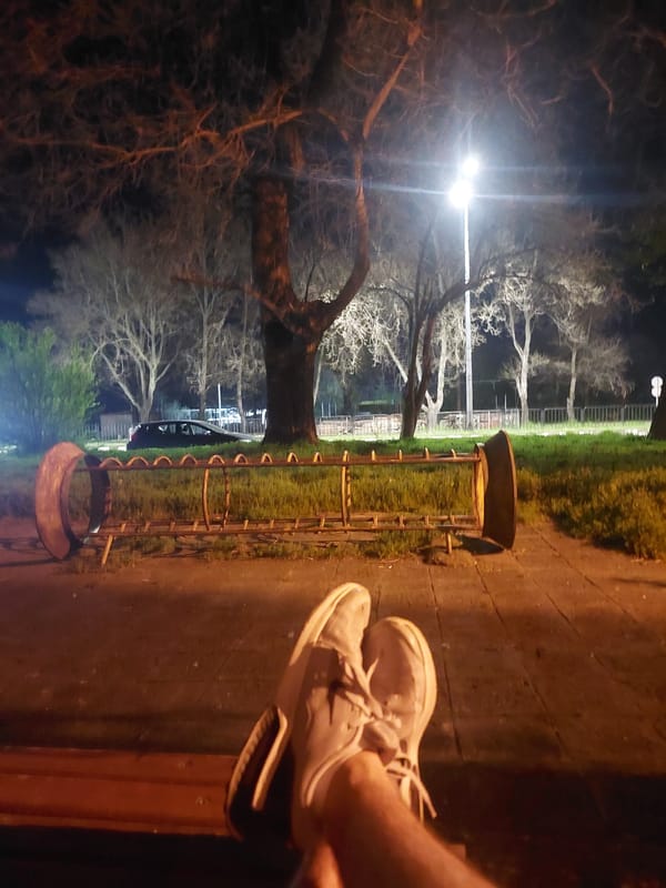 Person relaxes on park bench in Asenovgrad, Bulgaria