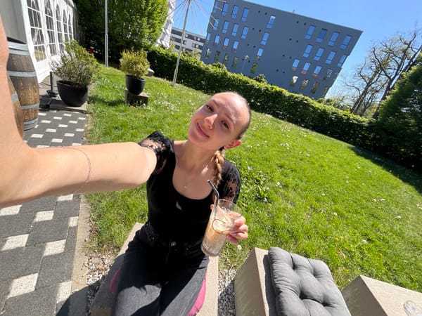 Woman enjoys iced coffee selfie moment in sunny Saarbrücken