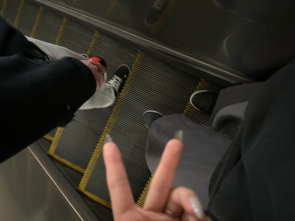 Two people ride escalator in Moscow subway station
