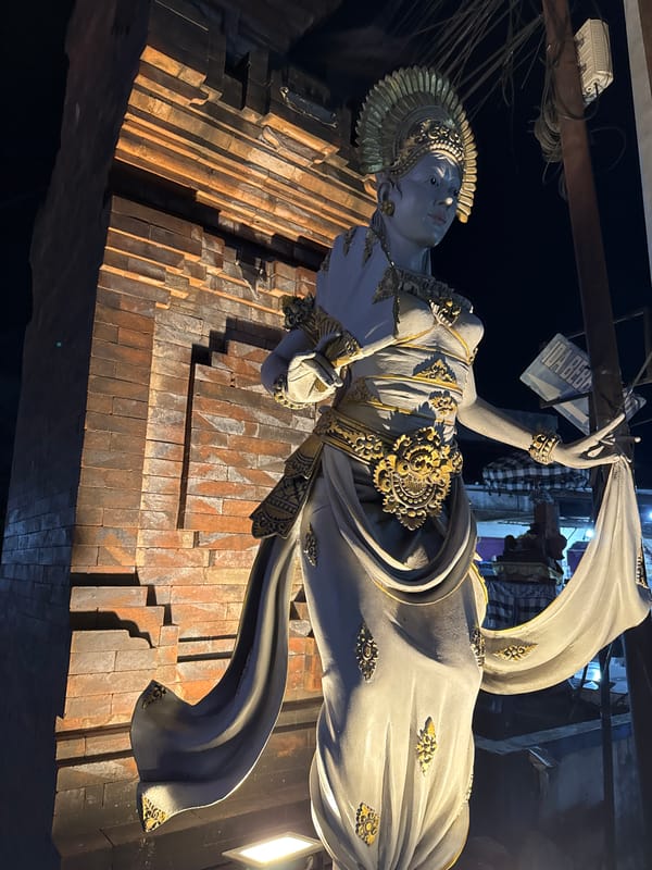 A Denpasar night: streets, statues, flowers, and winding down
