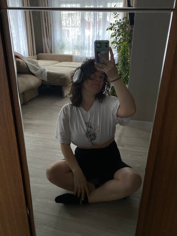 Woman Takes Mirror Selfie on Wooden Floor