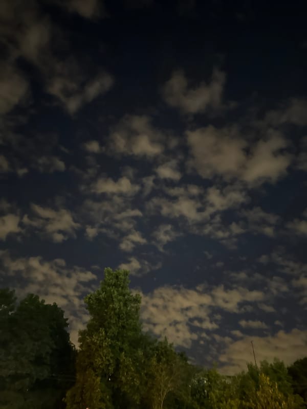 Moscow night sky glowing through scattered clouds near a construction site