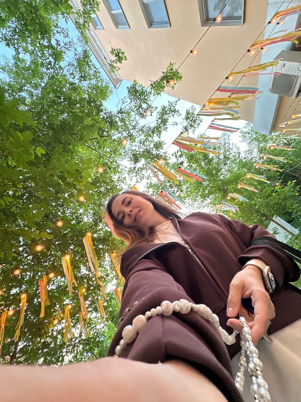 Woman takes selfie in decorated Perm courtyard during evening