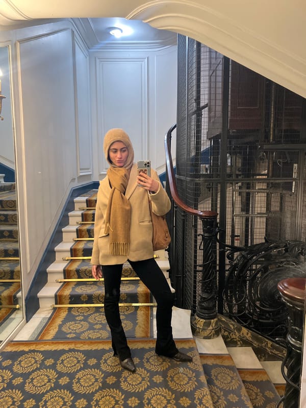Woman photographs herself on ornate Parisian staircase