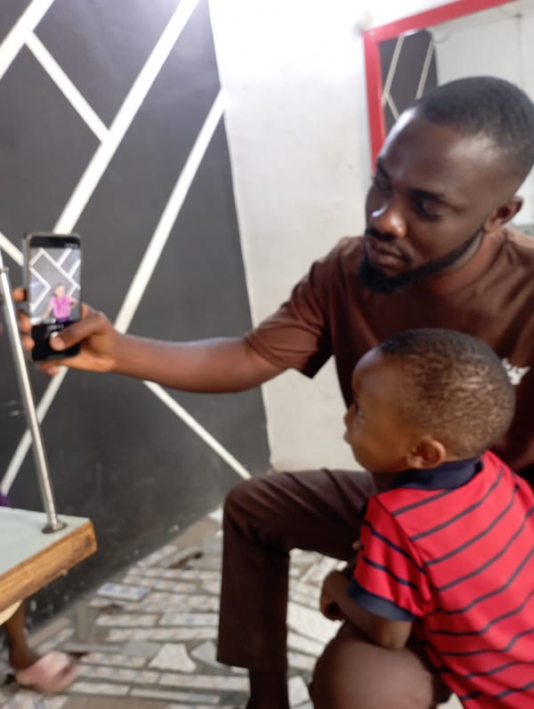 Man holds child while viewing photo on phone