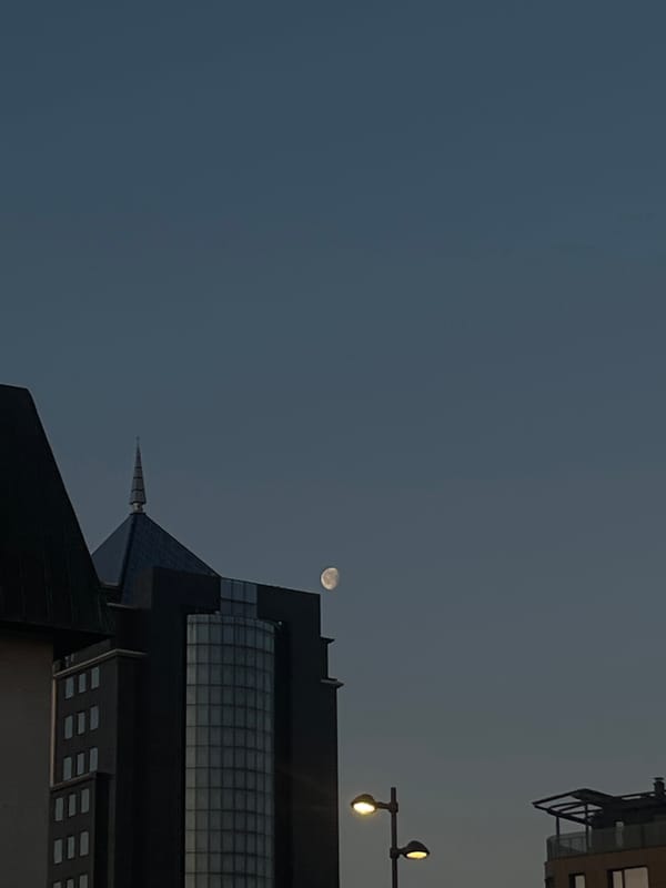 Nearly full moon observed over Plovdiv urban landscape at dawn