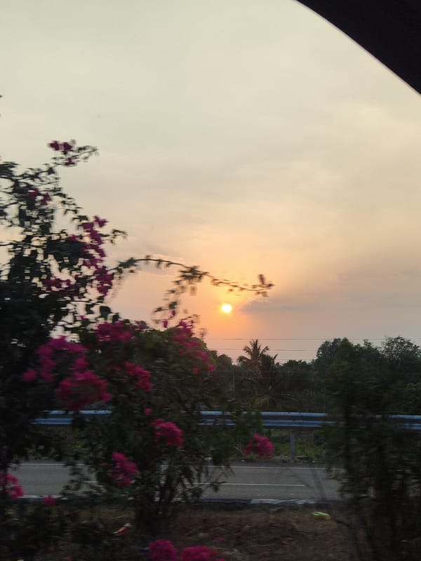 Hazy sunset observed over roadside scene in Aruru, India