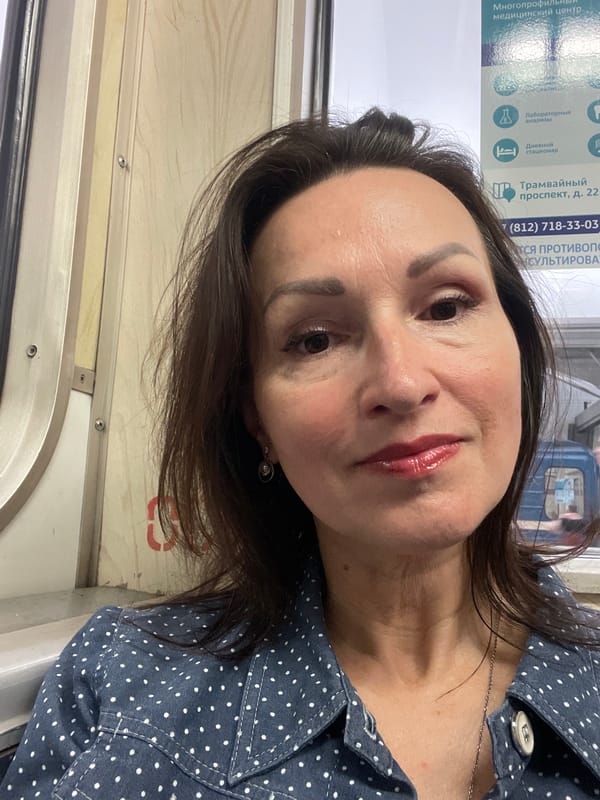 Woman rests on early morning commuter train in Shushary