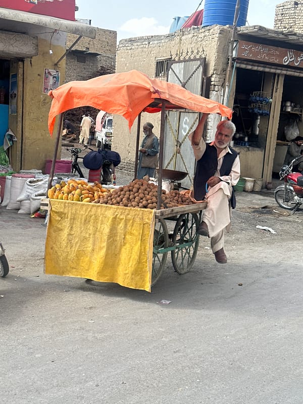 Elderly man rests on fruit cart in Quetta