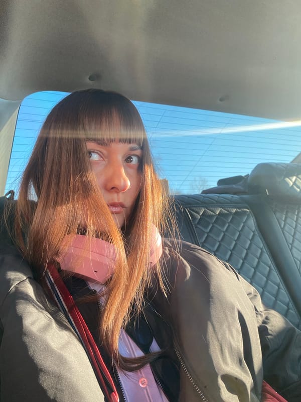 Person in pink headphones sits in parked car in Votkinsk