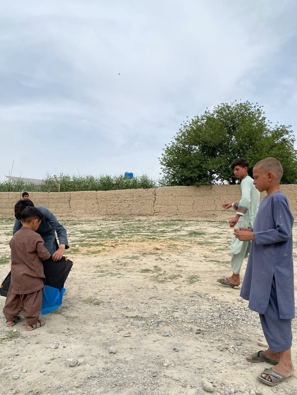 Boys fly kites in Kandahar field gathering