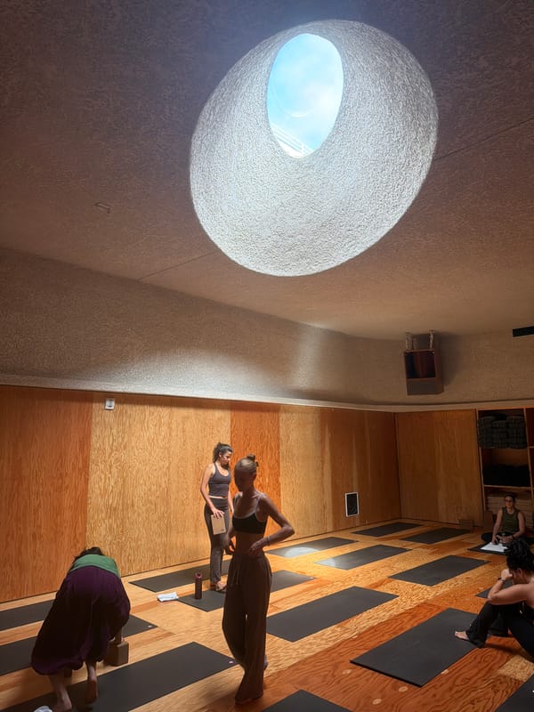 LA yoga studio mid-class, circular skylight and gong in frame