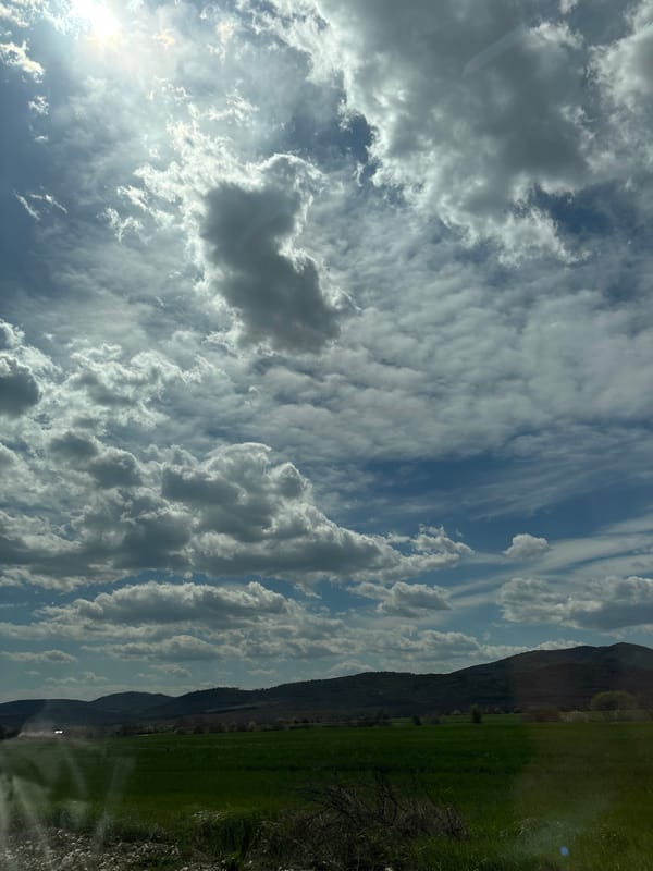 Sunlight breaks through cumulus clouds over Banya, Bulgaria