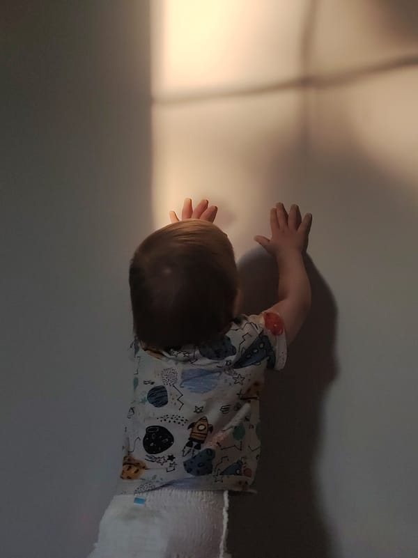 Child reaches for light, person adorned with facial rhinestones