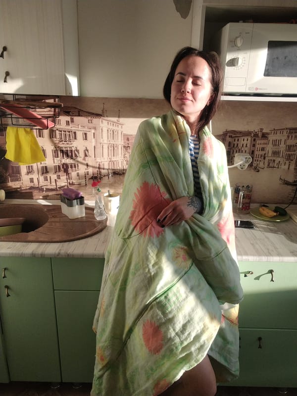 Woman enjoys morning sunlight in Russian kitchen with child