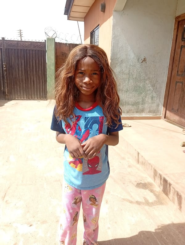 Girl in Spiderman shirt plays in Sabon Tasha courtyard
