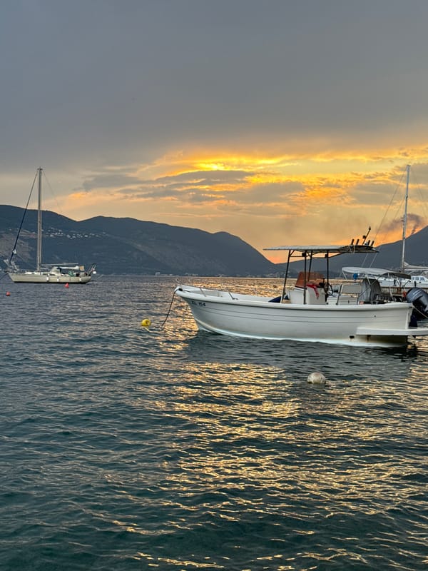 Sunset at a quiet mountain bay, boats and golden water